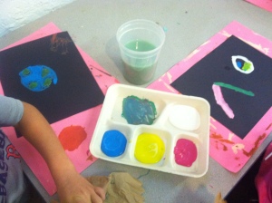 First graders use primary colors to mix their secondary colors.